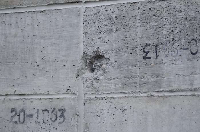 Close detail of ballistic impact craters in an Amidon Shield panel