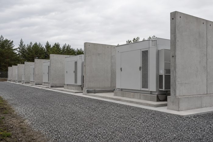 Containerized battery energy storage units separated by freestanding precast concrete blast walls