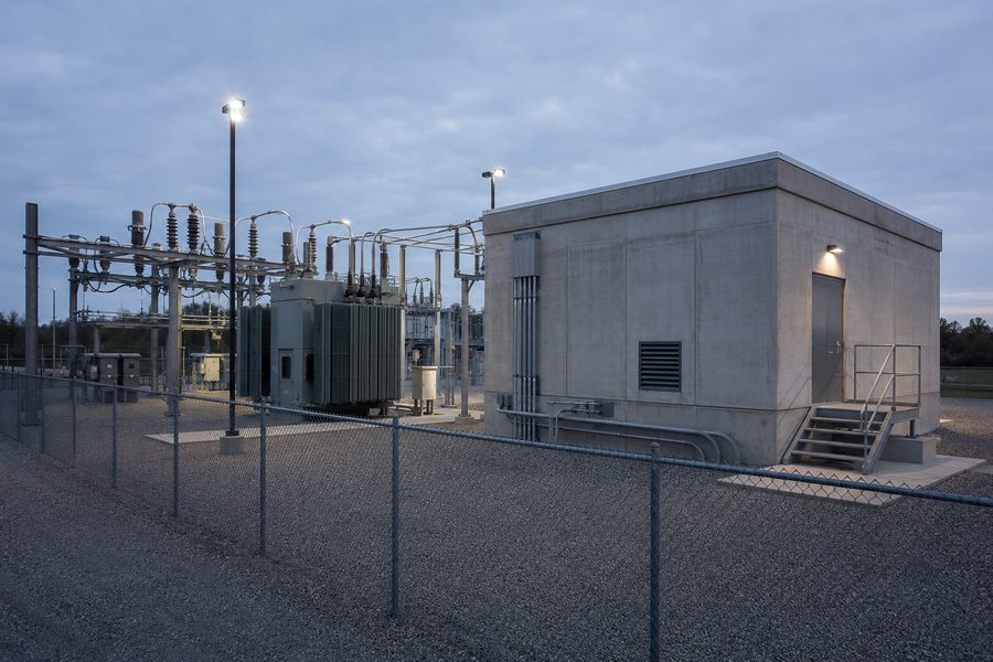 Electrical substation with a hardened concrete equipment enclosure at dusk