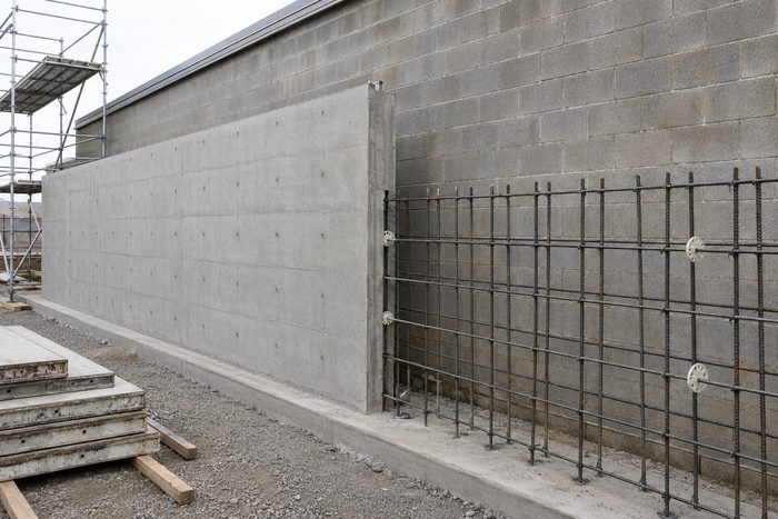 A new reinforced concrete wall being cast against an existing masonry block wall to harden it
