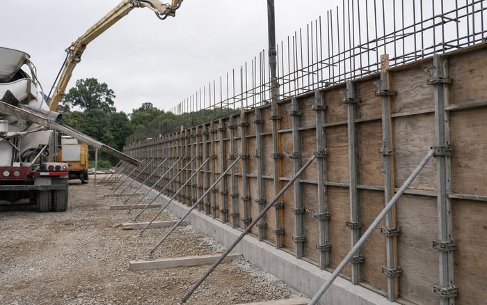 Fresh concrete being poured into a reinforced wall form